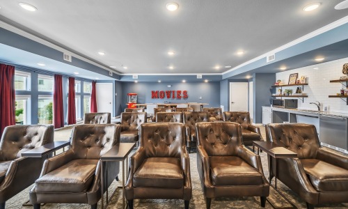 a movie theater with lounge chairs and a popcorn machine