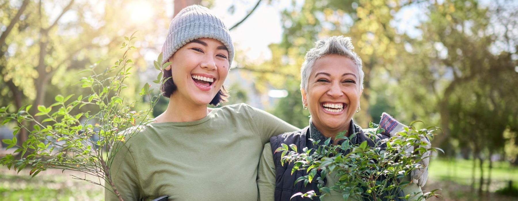 a couple of women holding plants